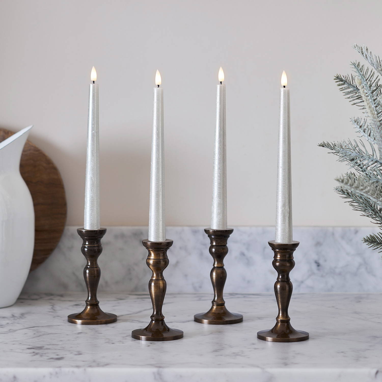TruGlow® champagne LED taper candles on a marble countertop.