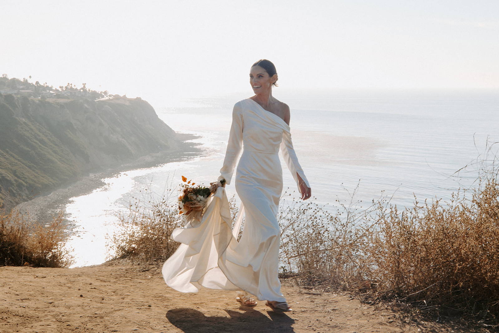 Bride walking in the Anu Gown near the beach