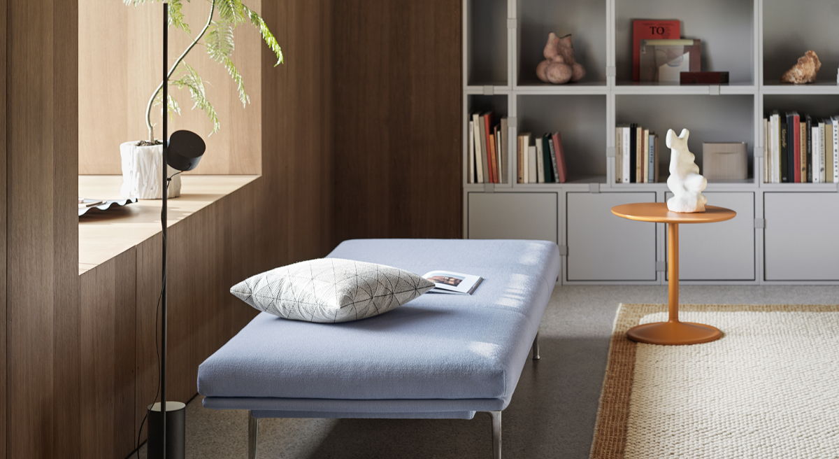 Modern interior with a blue lounge chair, wooden shelves, and decorative items.