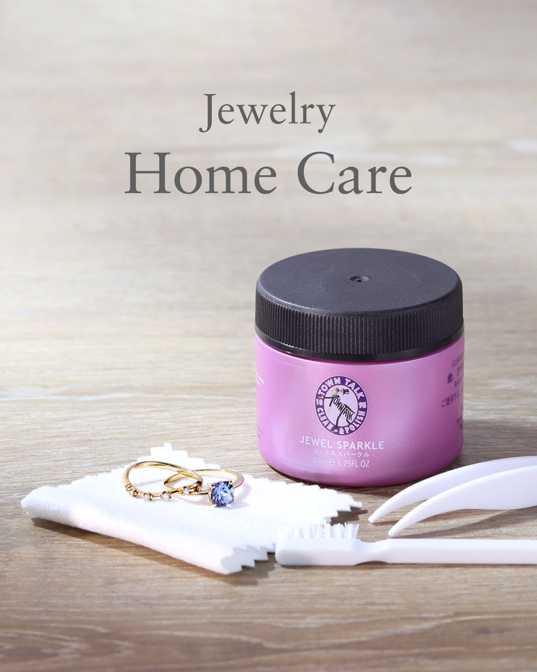 Jewelry cleaning products with a ring and brushes on a wooden surface.