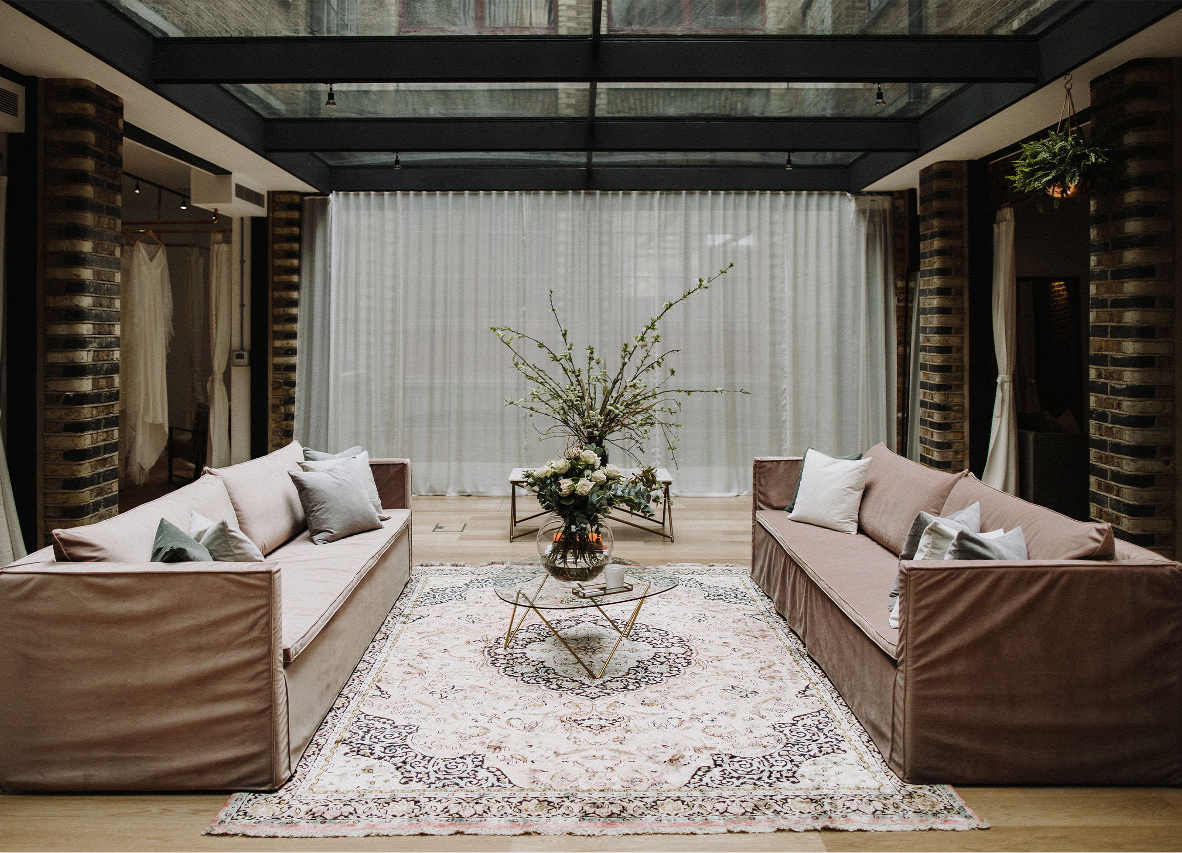 Two sofas facing each other with a coffee table and decorative plant in between.
