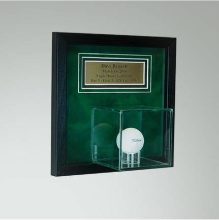 Golf display case with an engraved plaque.