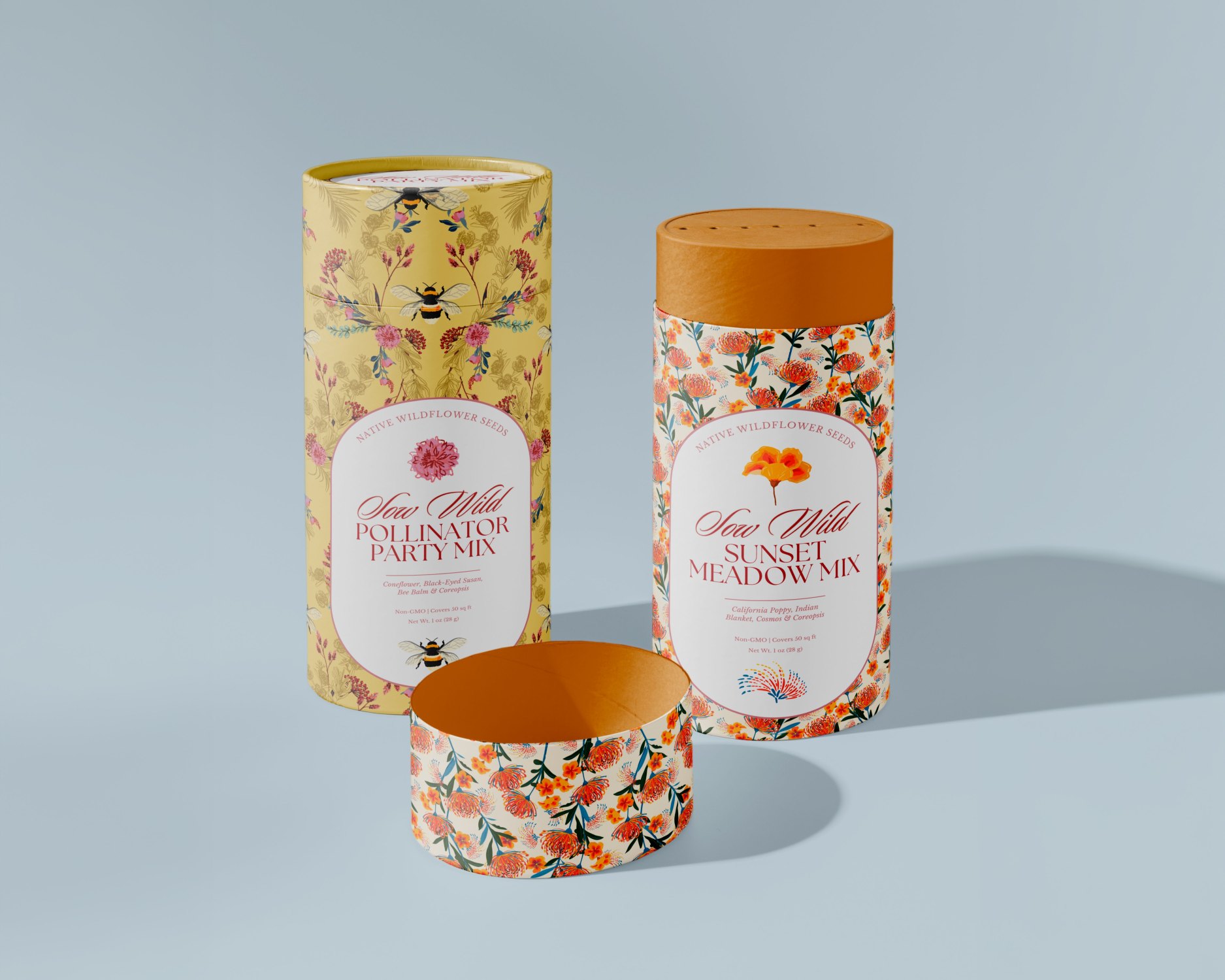 Three decorative paper tube containers with floral designs on a blue background.