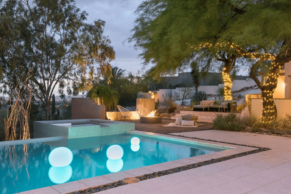 Elizabeth Przygoda's HGTV award winning outdoor design illuminated at night with floating pool lights. 