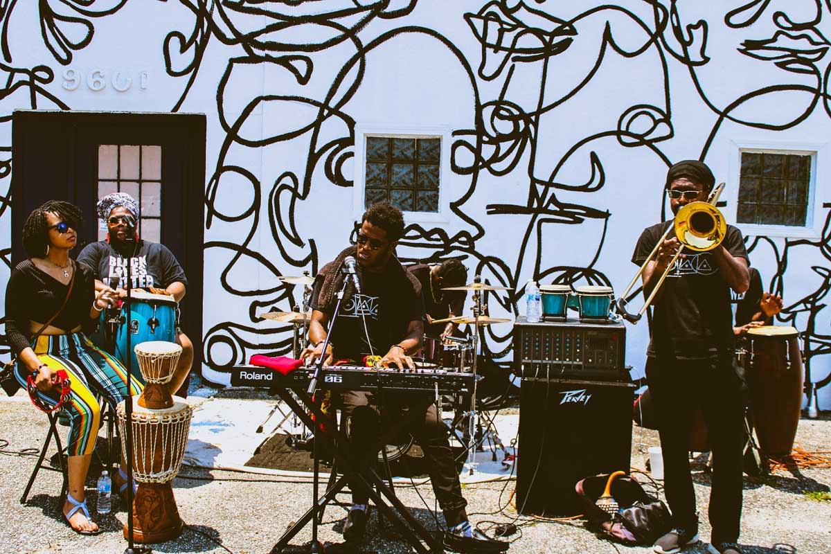 A group of black musicians playing on the street