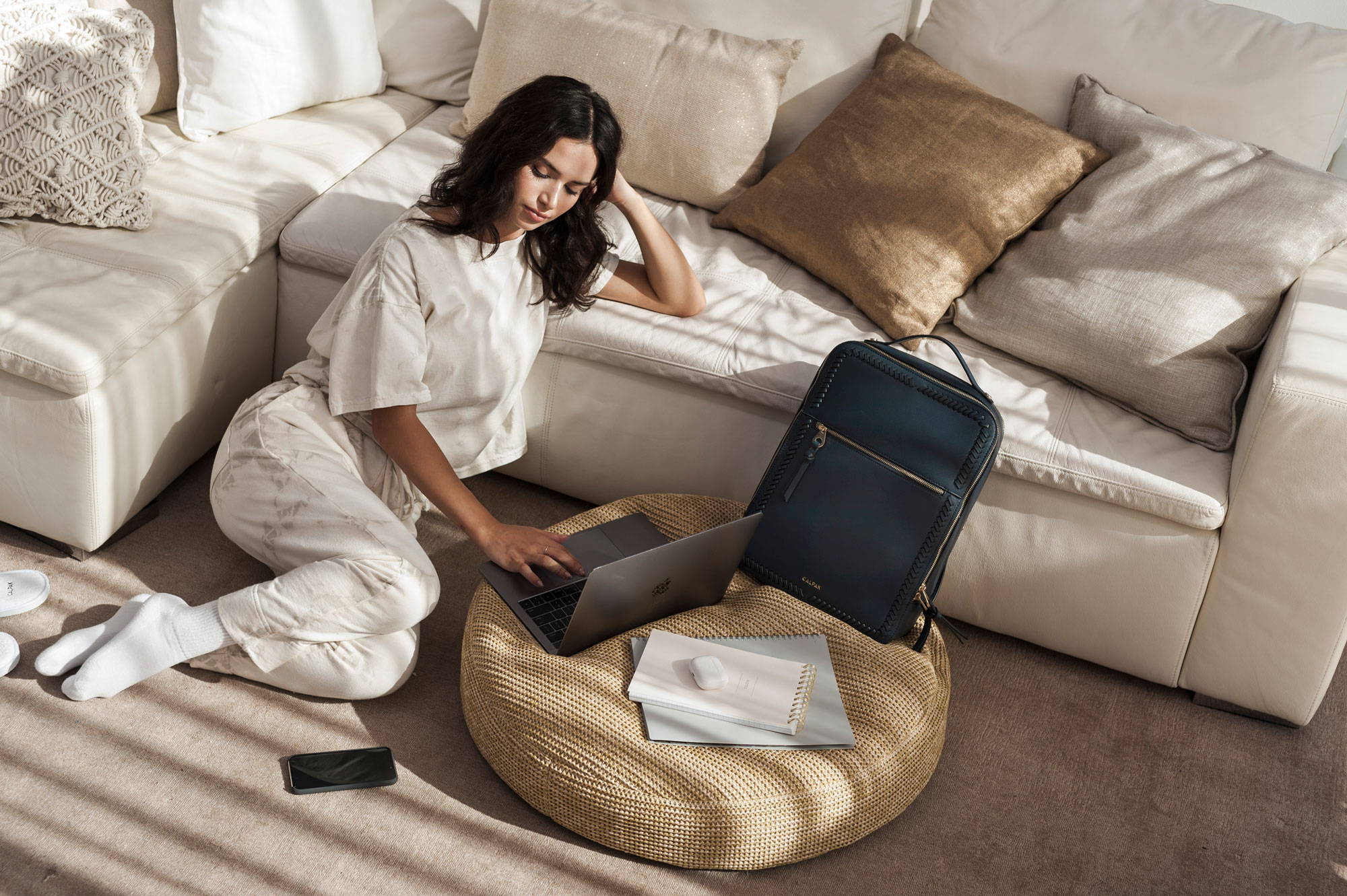 Model working at home with the Kaya Laptop Backpack