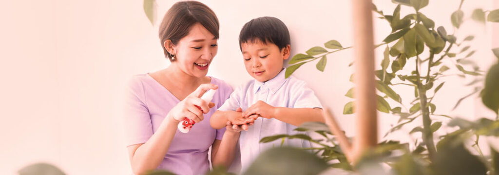 A woman and child engaging with a toy or activity among plants.
