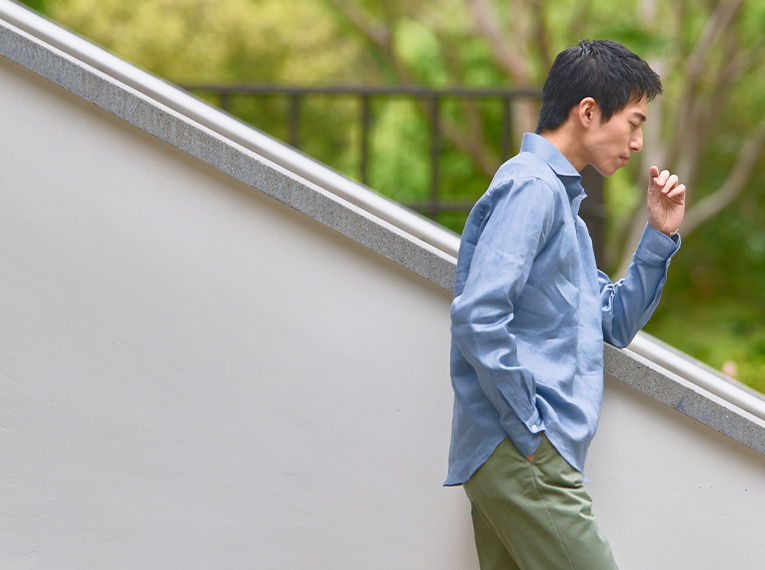 A person walking down stairs, looking thoughtful in a casual outfit.