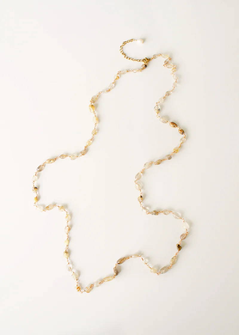 a gold necklace adorned of natural coloured crystal pebbles