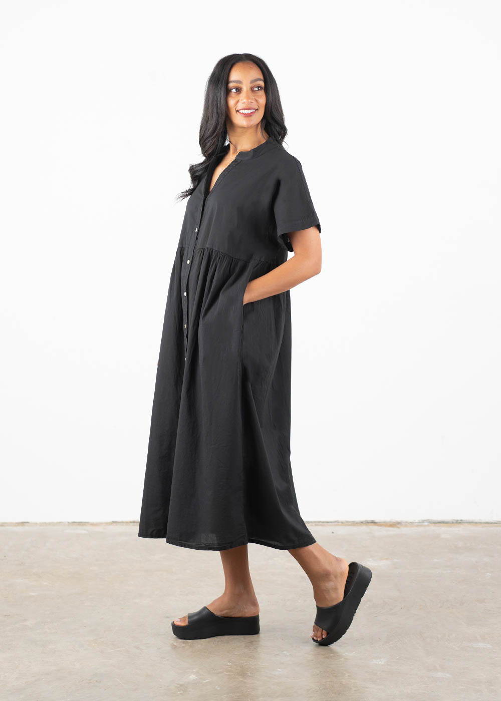 A model wearing a loose, oversized midi dress in a deep jet black