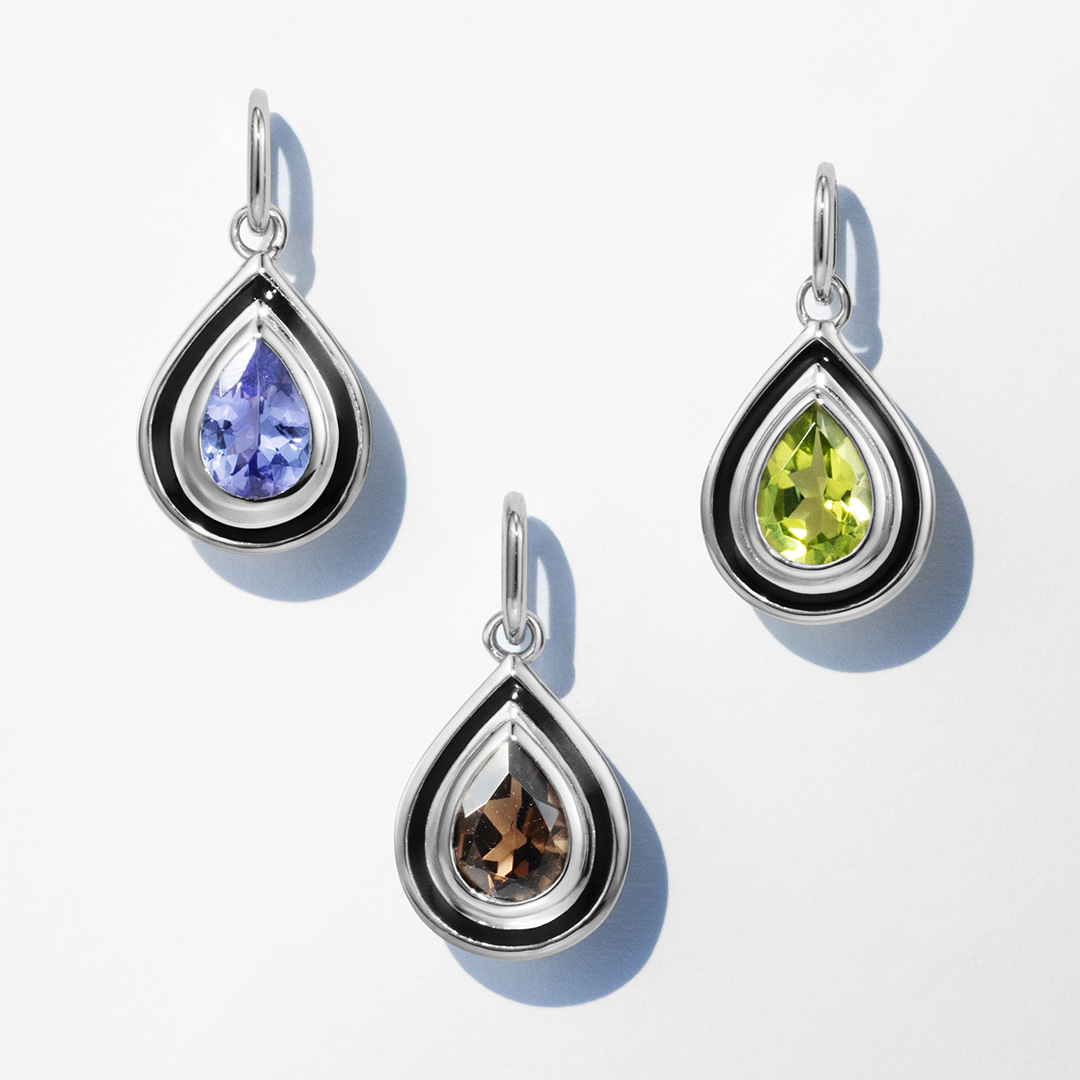 Three teardrop-shaped pendants with different colored gemstones.
