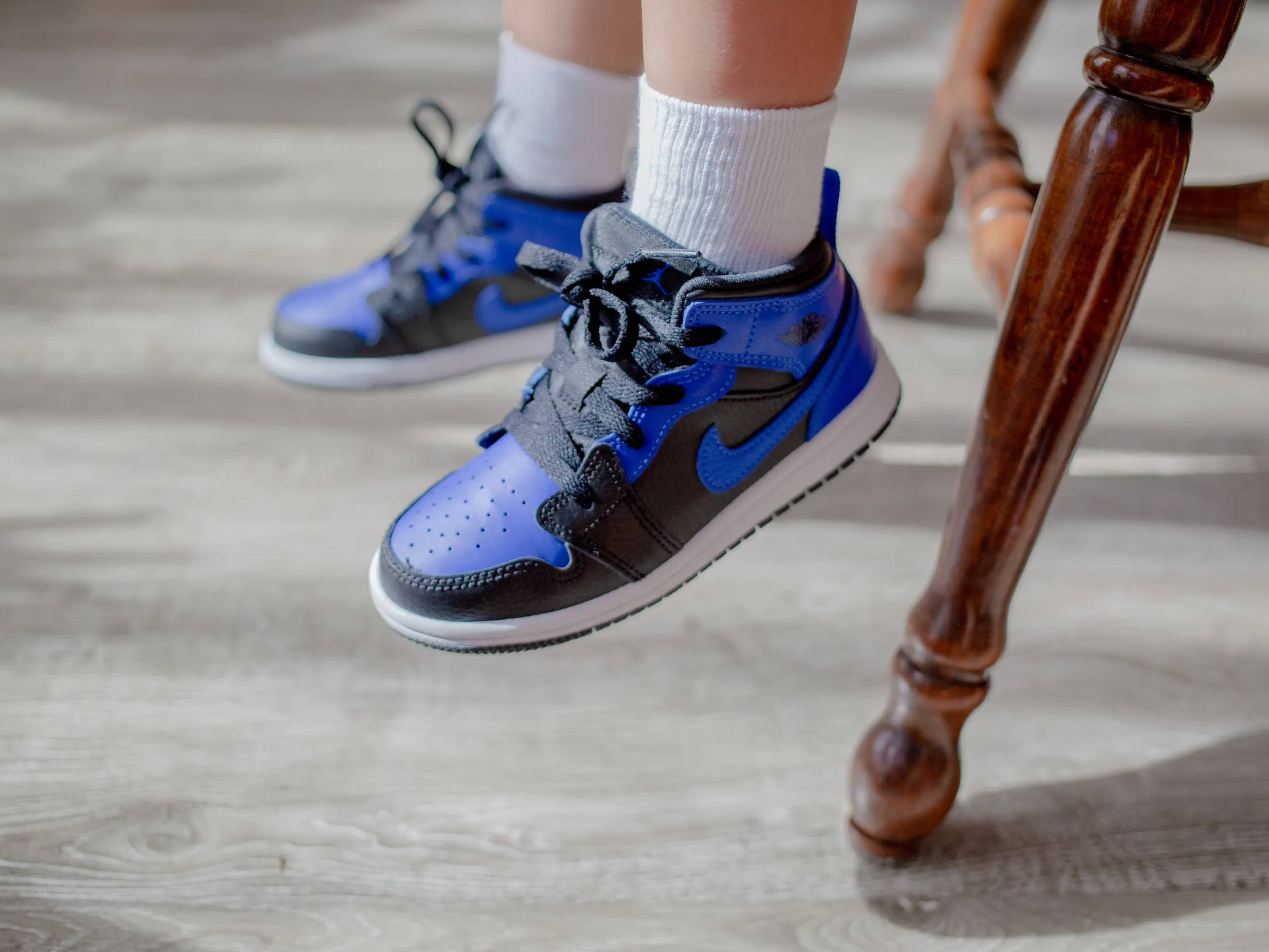 closeup of black and blue jordan ones on child's feet