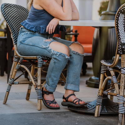 Woman sitting at table wearing Samara walking sandals
