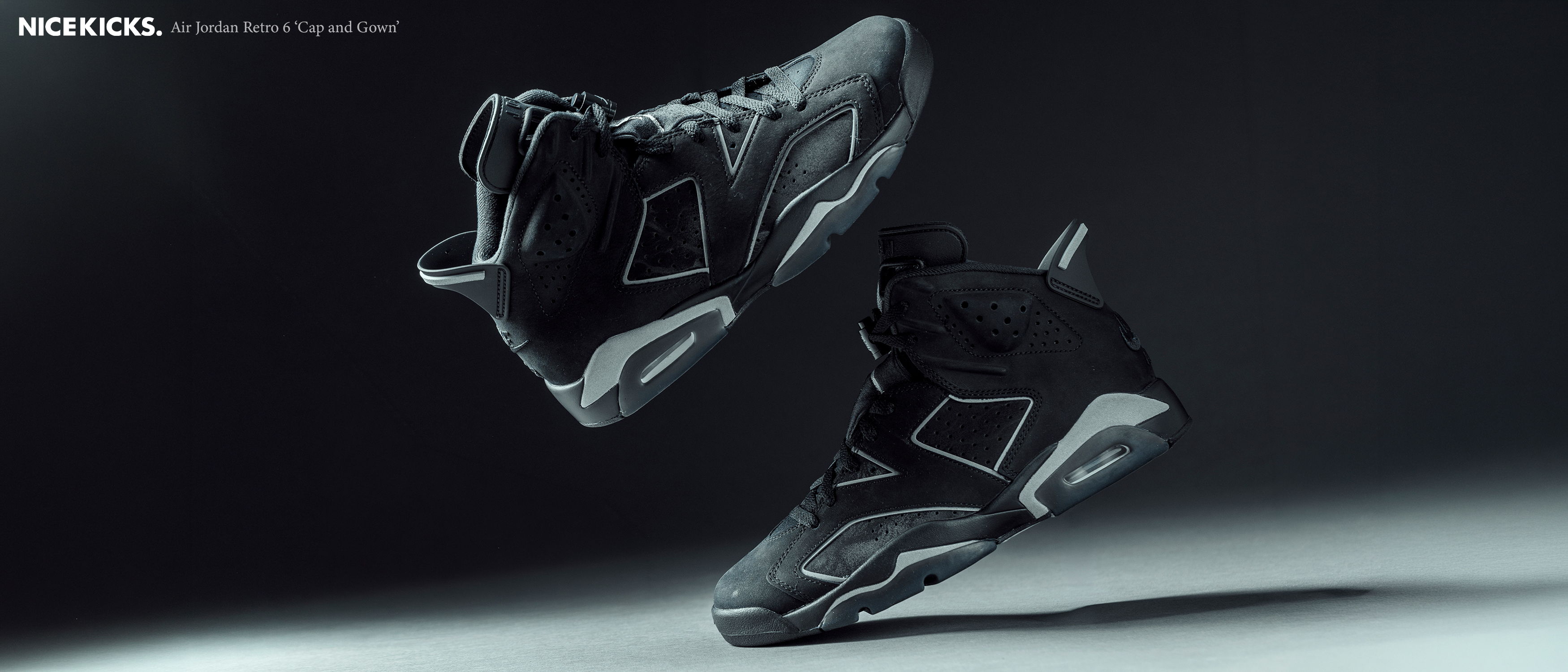 Black athletic shoes floating against a dark background.