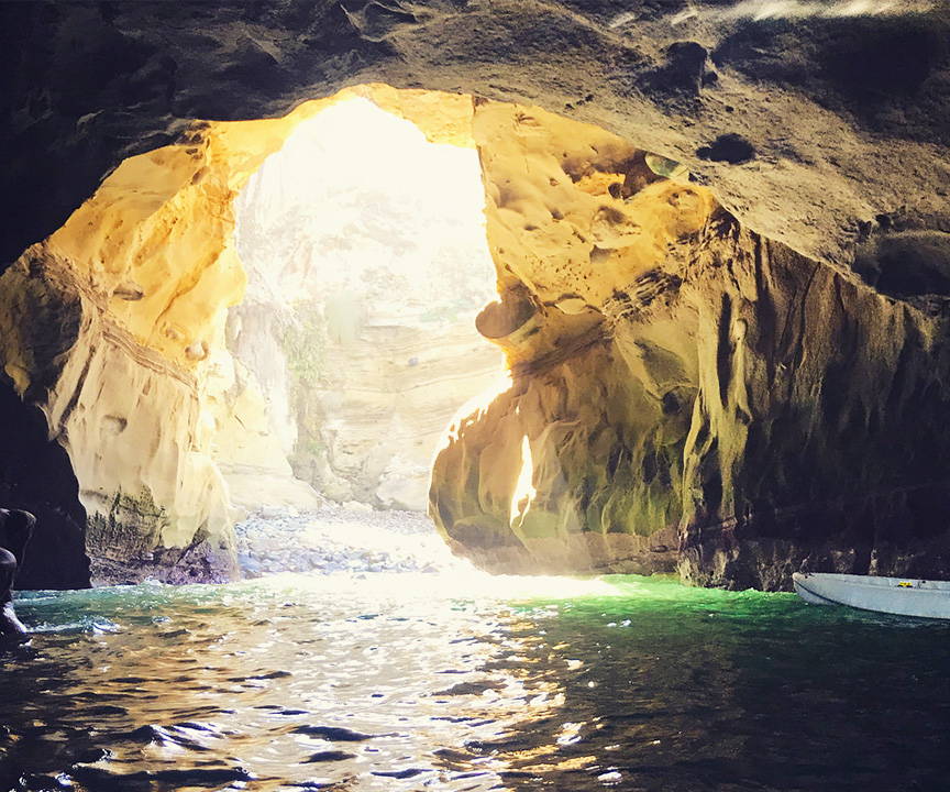 A photo of the inside of a sea cave in La Jolla. The righthand and lefthand side of the photo are framed by rocky formations.