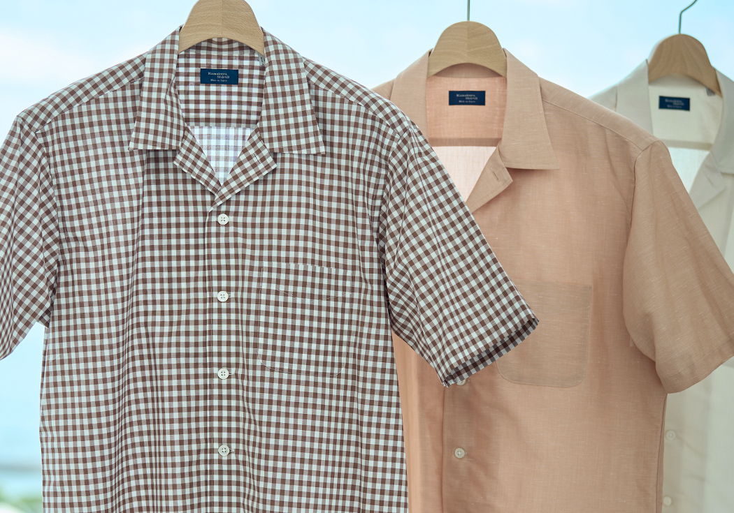 Three short-sleeve shirts hanging on hangers, featuring different colors and patterns.