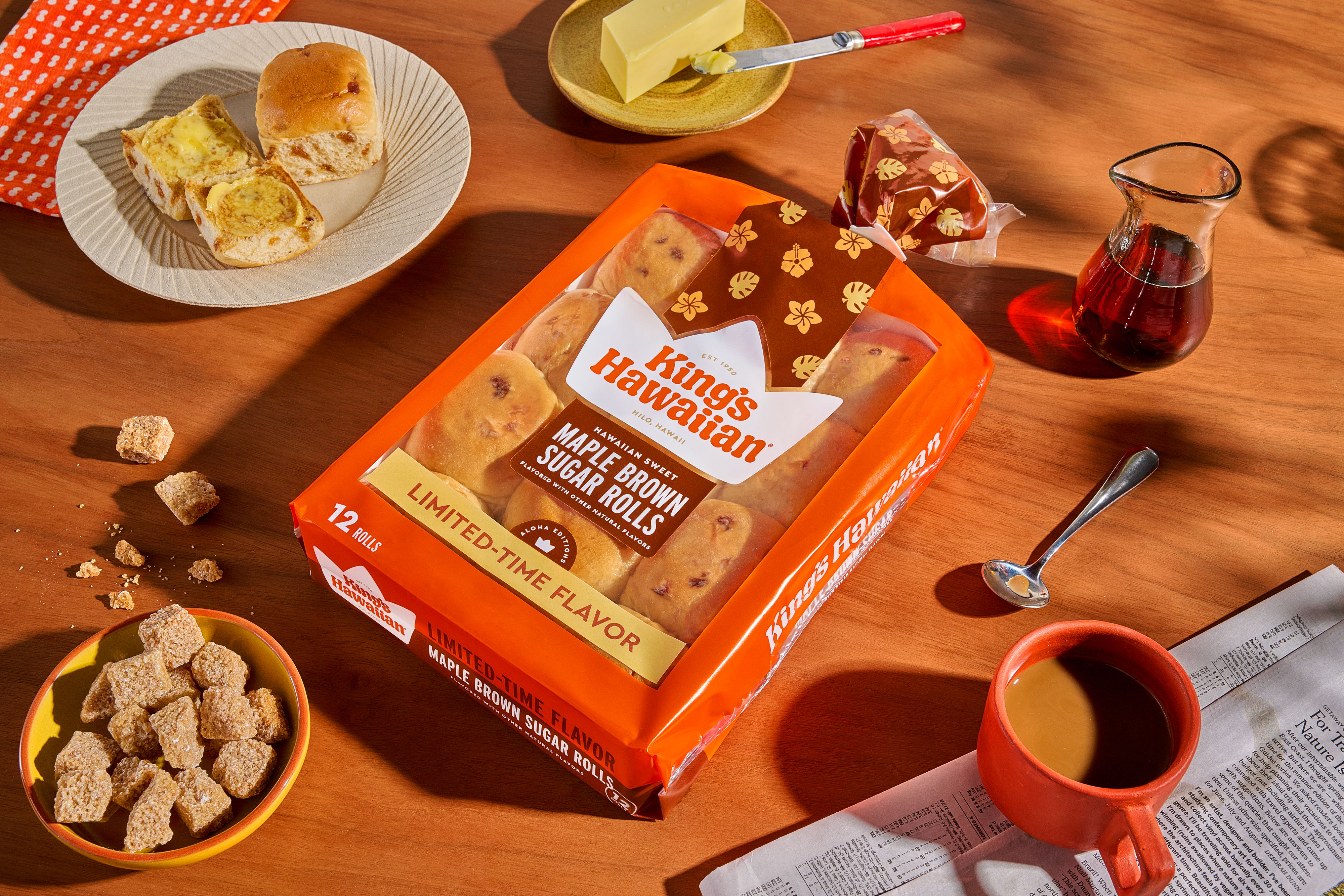 A breakfast scene with cookies, coffee, syrup, and buttered bread.