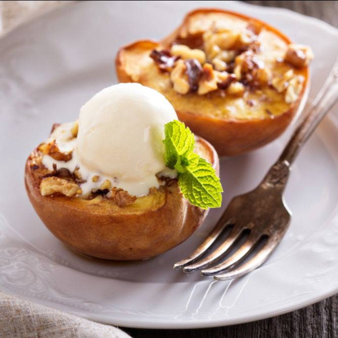 grilled peaches with ice cream and a mint leaf