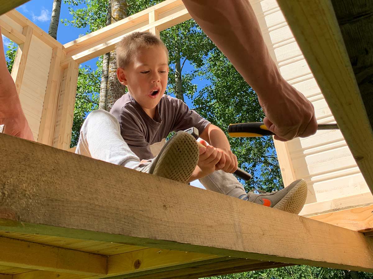 One boy helps build  a Kids Wooden Playhouse by WholeWoodPlayhouses