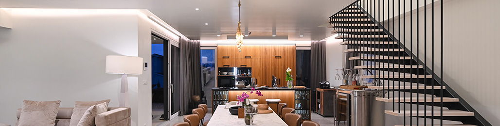 Modern interior featuring a staircase, kitchen, and dining area.