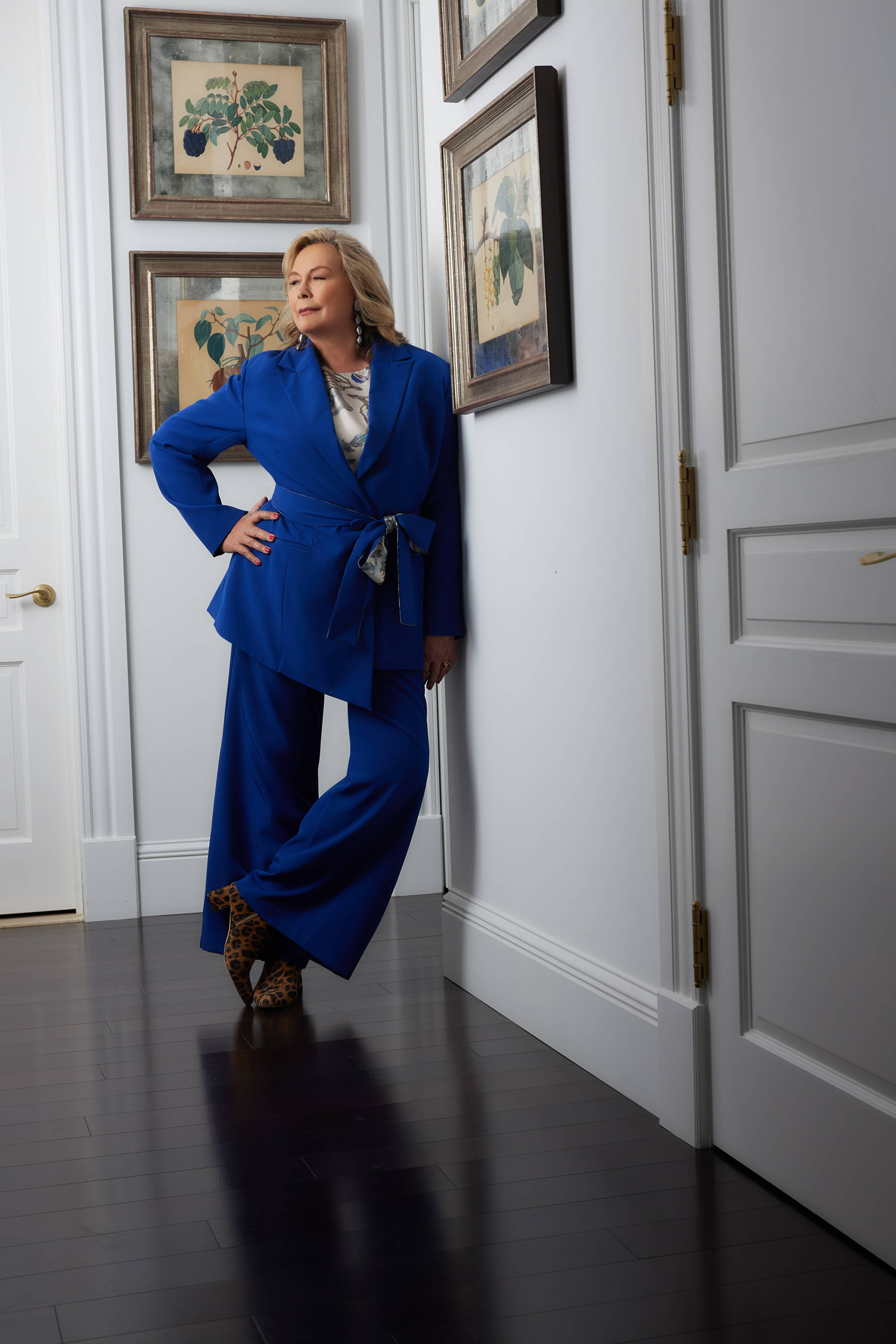 Ala Isham wearing blue silk lined suit jacket with matching pants in her apartment in New York City
