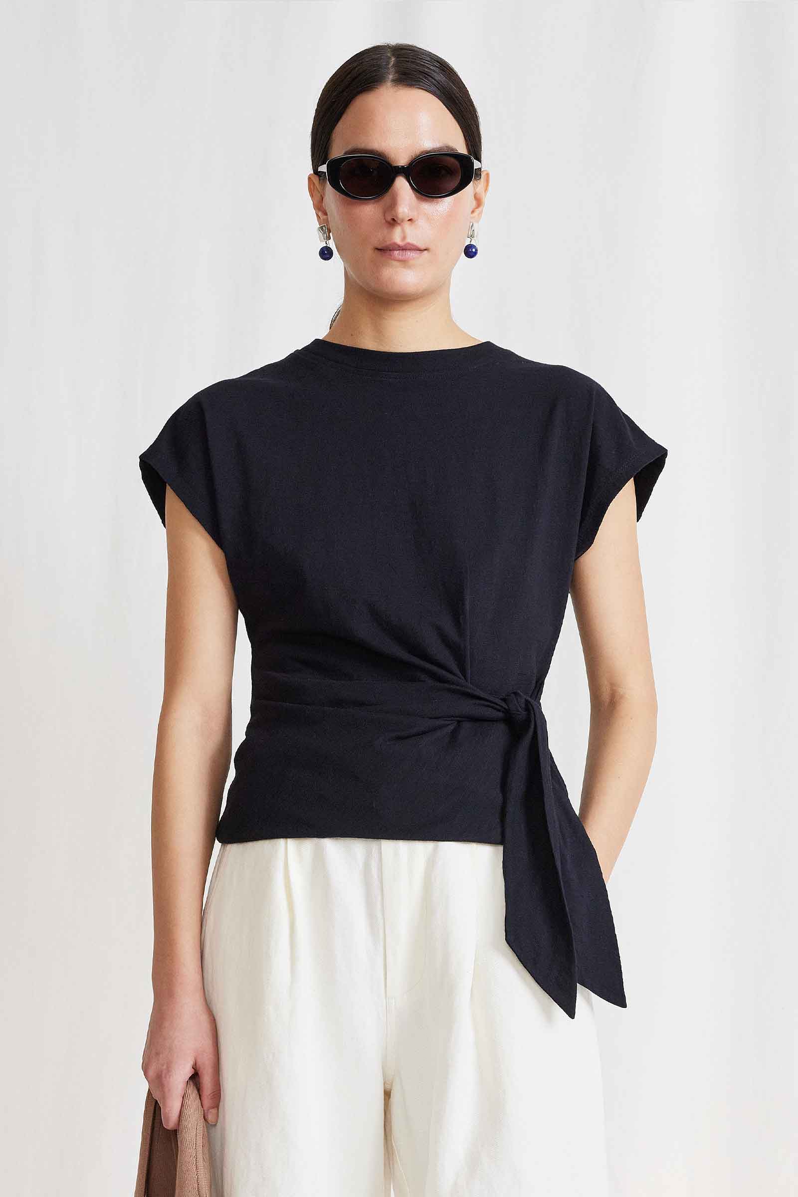A lookbook image of a model wearing the Apiece Apart Nina Cinched Top Black.