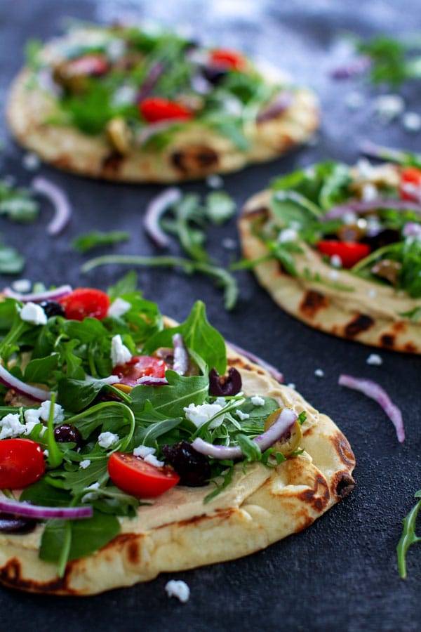Flatbread topped with arugula, red onion, cherry tomatoes, calamata olivesa and crumbled feta cheese.