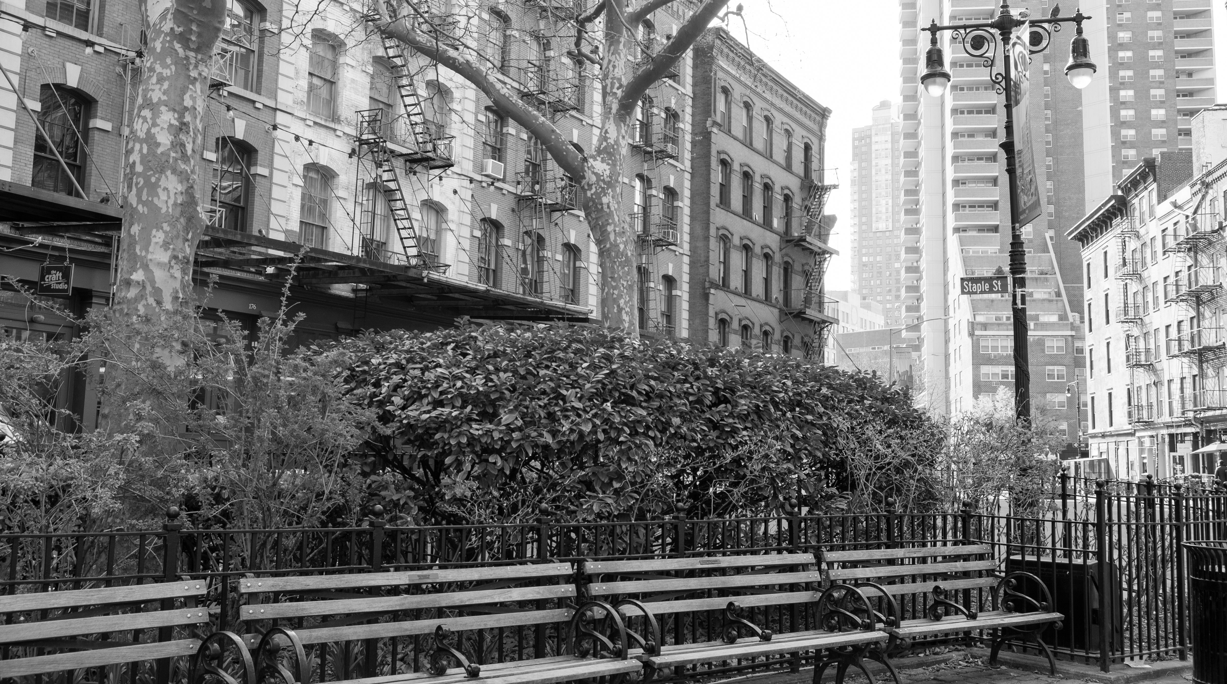 Black and white urban scene with buildings and benches.
