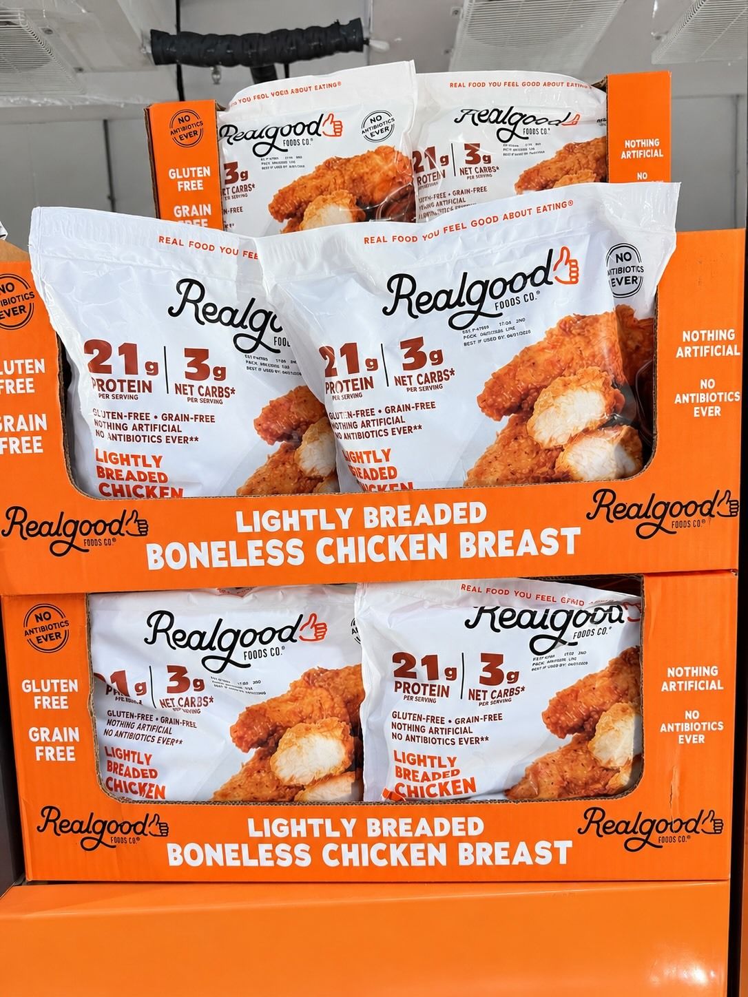 Packaging of Realgood lightly breaded boneless chicken breast in a display.