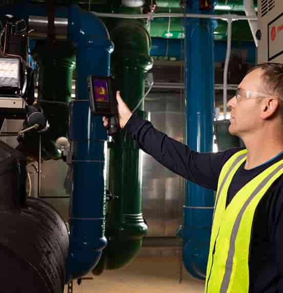 Technician using a FLIR iXX Series thermal camera to inspect industrial chiller equipment | GoThermal