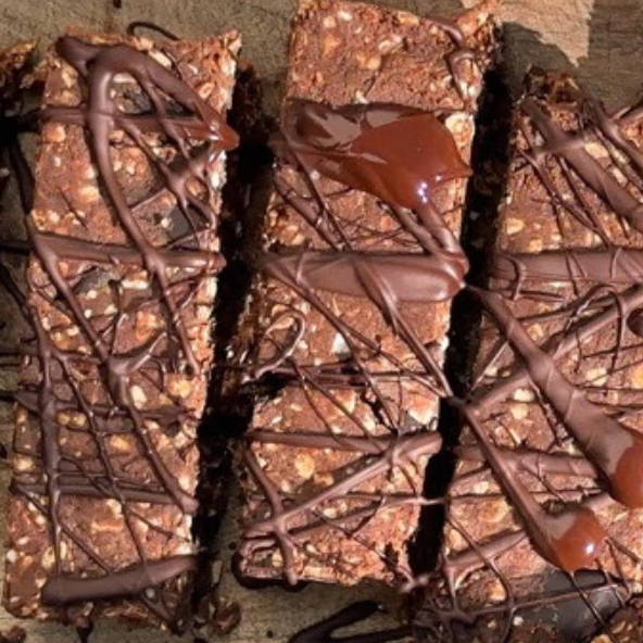 Chocolate bars drizzled with chocolate on a wooden surface.
