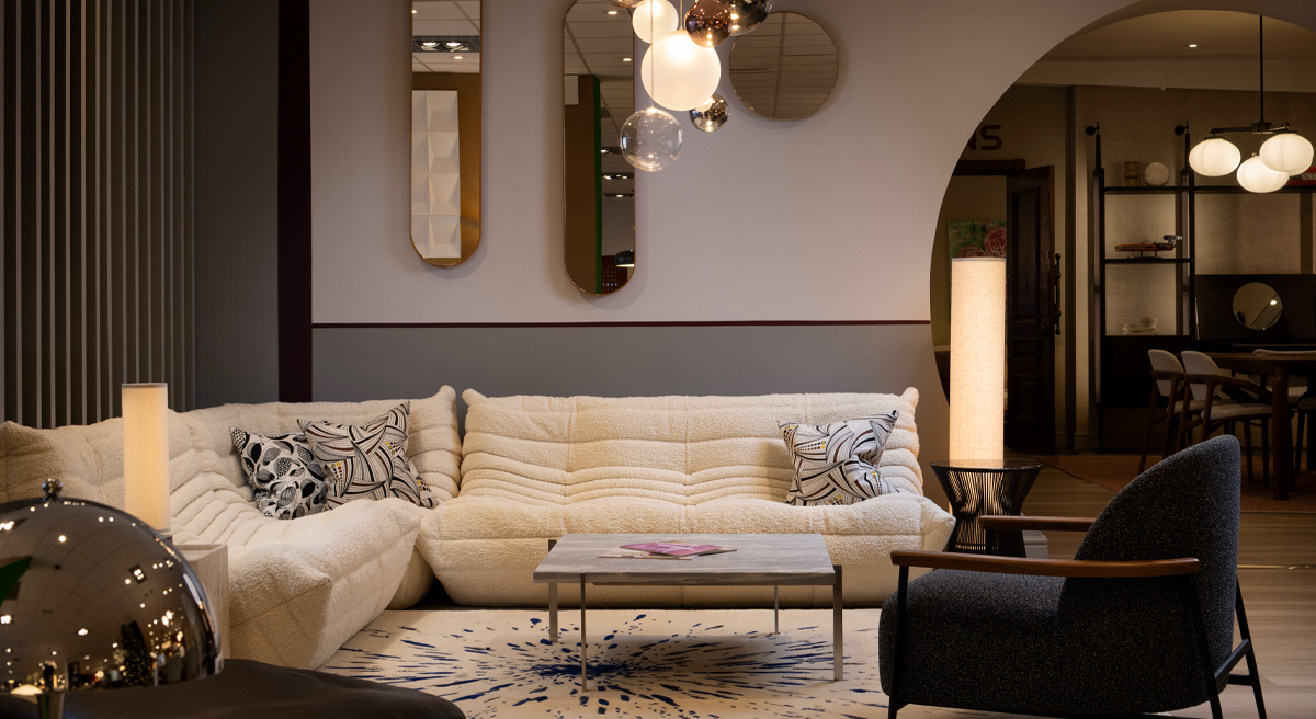 Wide angle image of the Chaplins Furniture showroom with a sectional Togo sofa, coffee table, and stylish lighting.