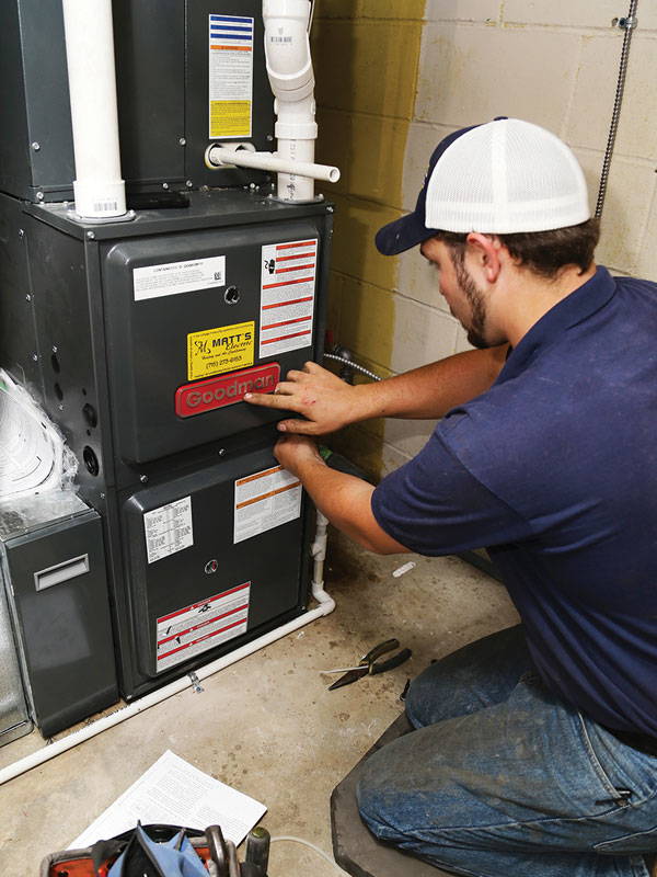 HVAC professional replacing gas furnace in home
