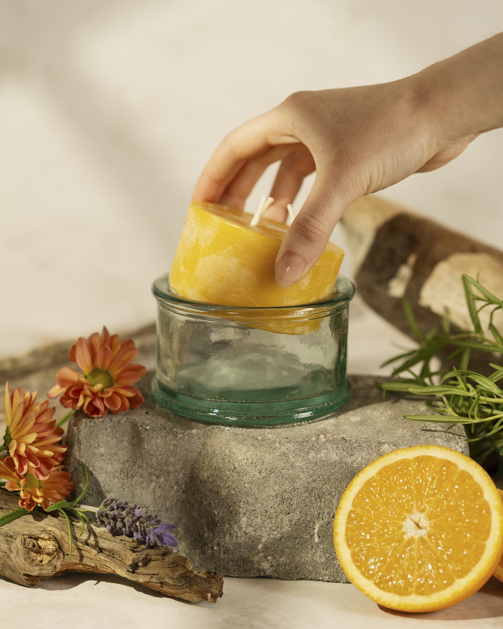 Hand placing beeswax refill into glass holder