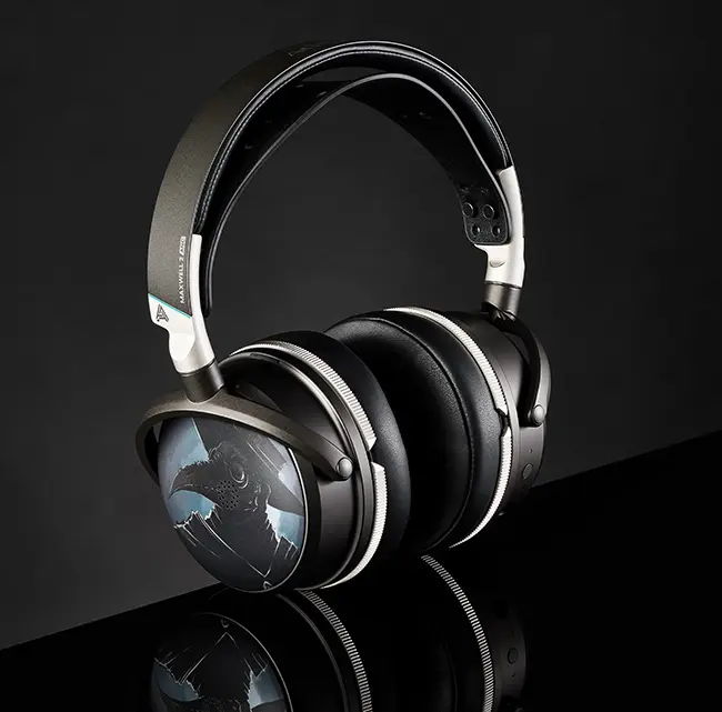 A pair of black headphones on a reflective surface against a dark background.