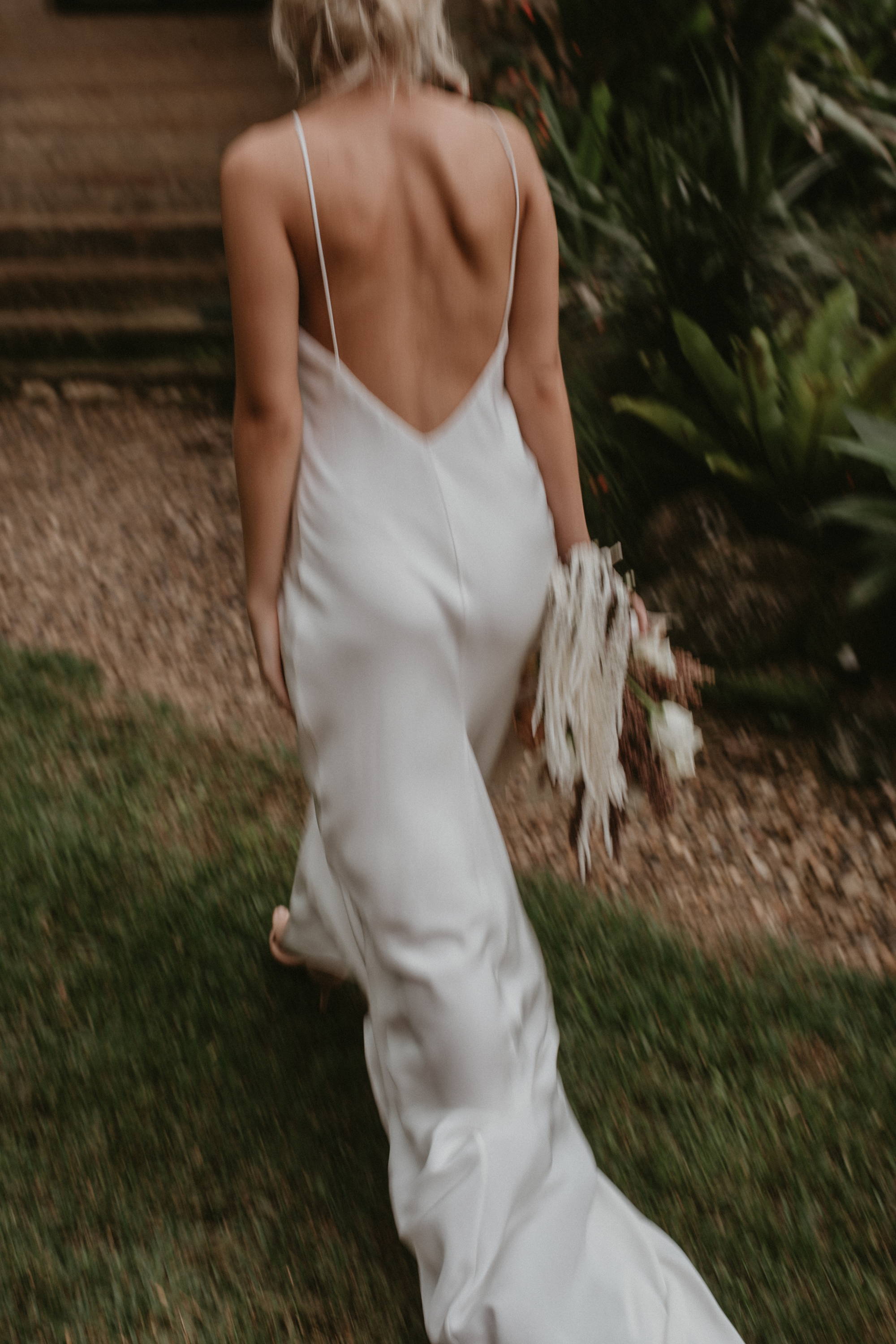 Bride walking wearing a low v back silk dress