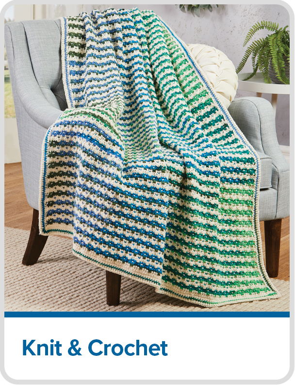 Colorful knit and crochet blanket draped over a chair.