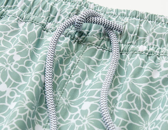 Close-up of green floral patterned shorts with a drawstring.