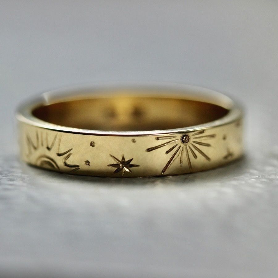 Hand-engraved wedding band with suns and stars