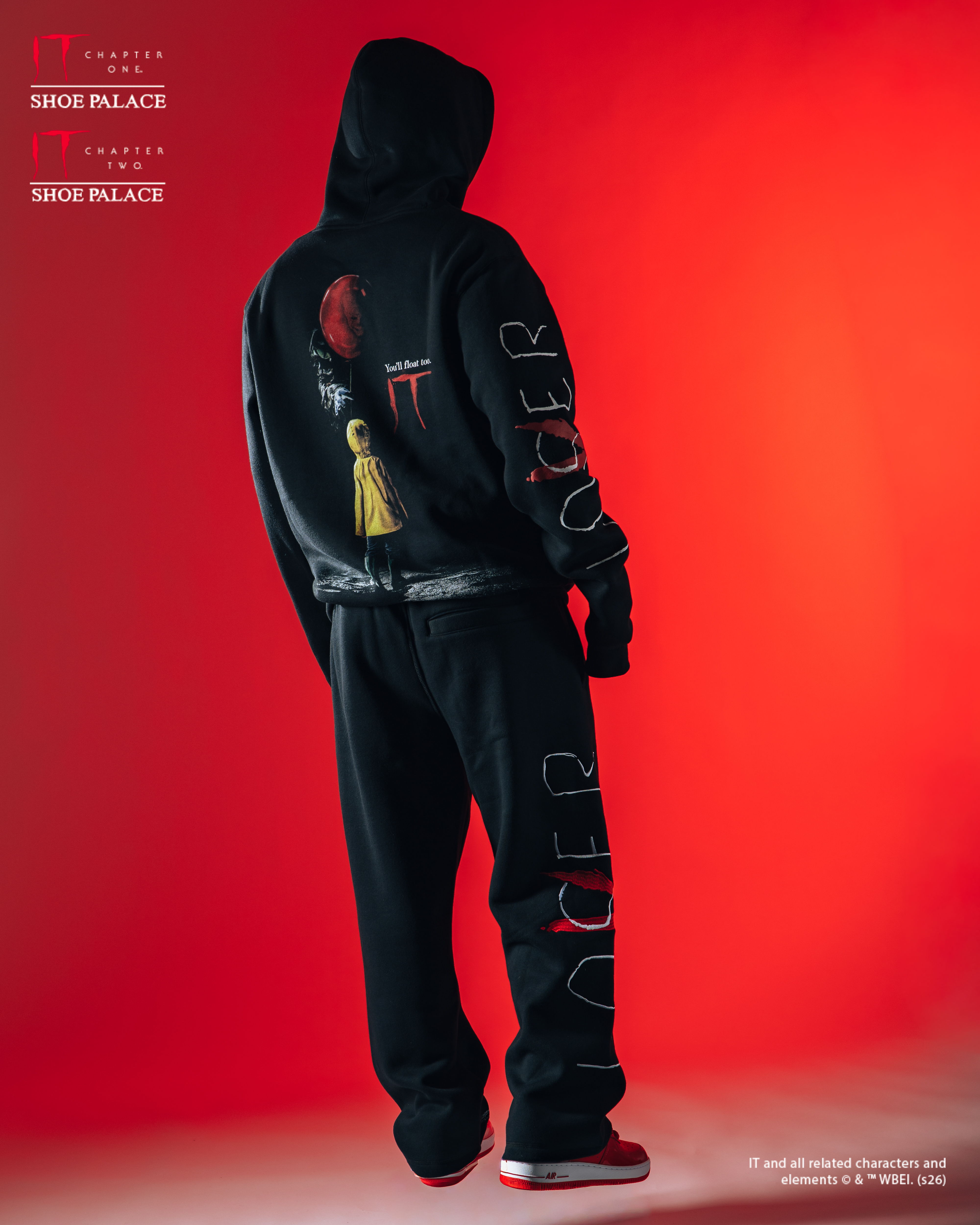 Person wearing black hoodie and sweatpants against a red background.