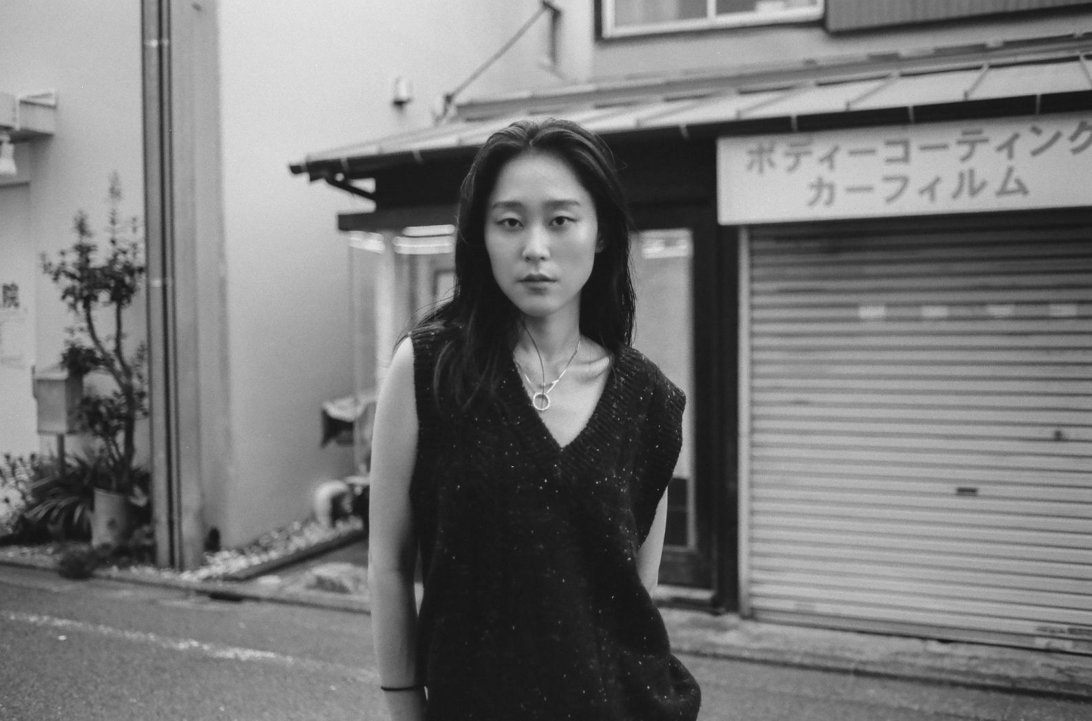 A woman standing on a street in black and white.