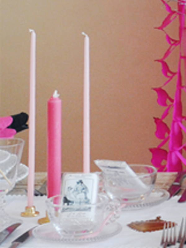 A close up of the pink candles on the Hen Do table with pearl tea cups filled with wedding chocolate bars.