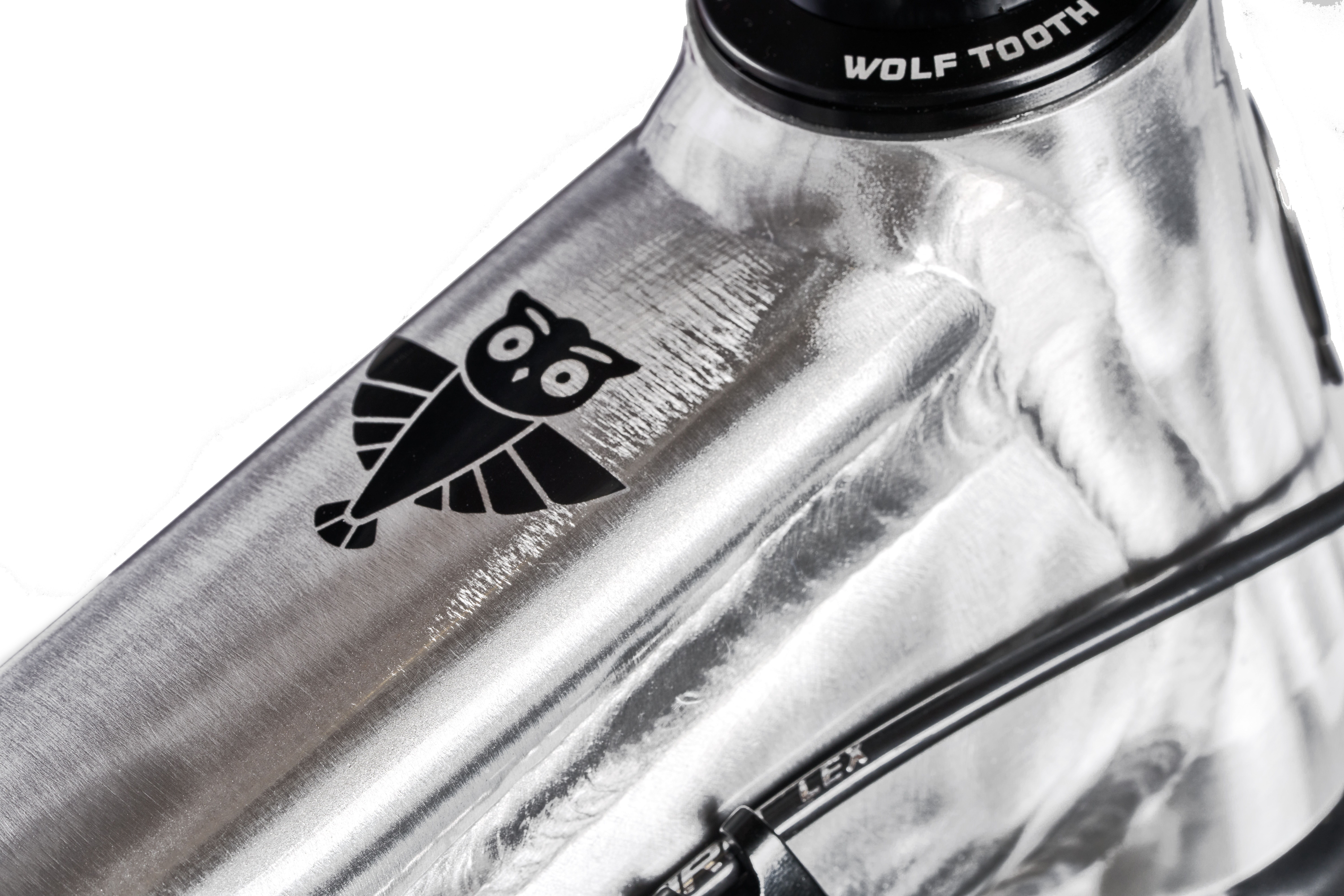 Black owl logo on a silver bicycle frame.