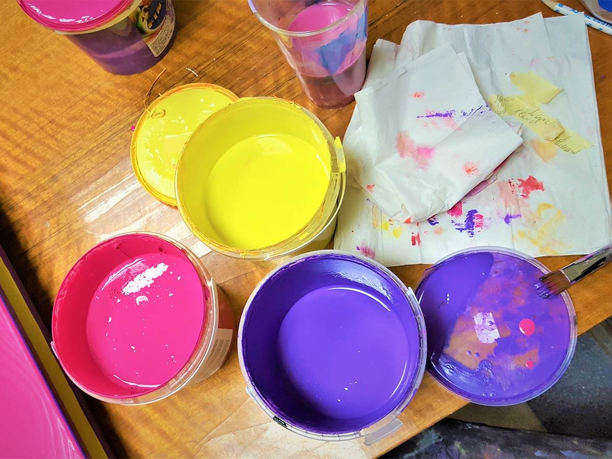  There are paint cans in different colours on the table by WholeWoodPlayhouses