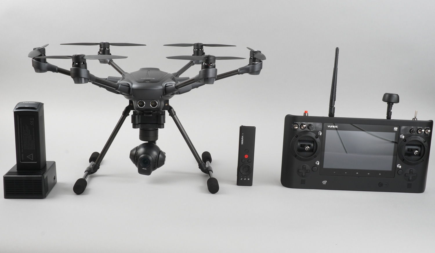 A Typhoon H resting beside batteries and remote controllers with a white background