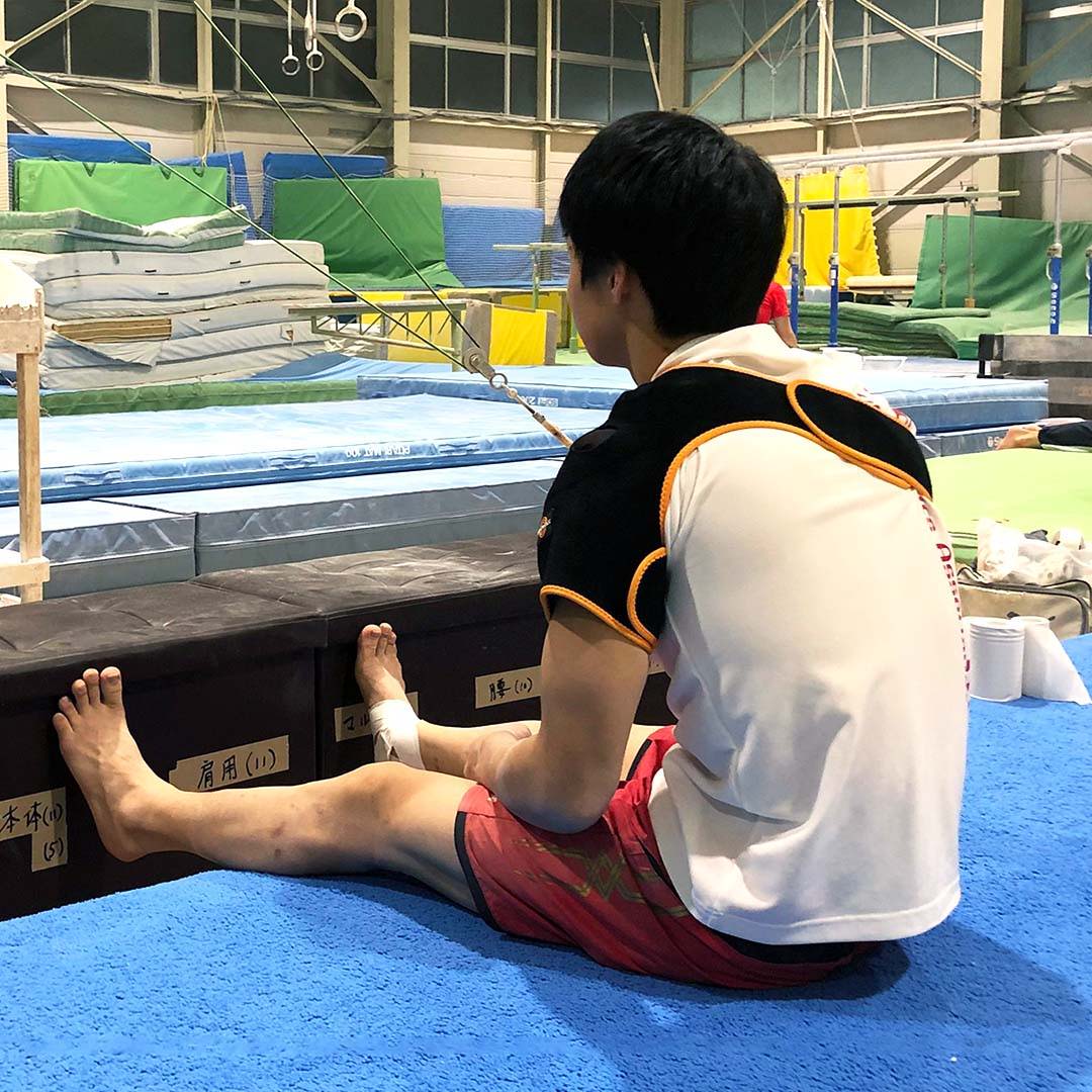 Osaka University Gymnastics team using Myovolt wearable vibration therapy for muscle warm-up and recovery.