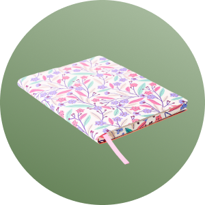 A colorful patterned notebook with a pink ribbon bookmark.