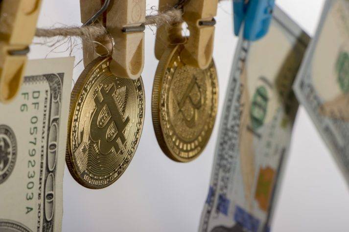 Money and Bitcoin coins hanging from clothesline