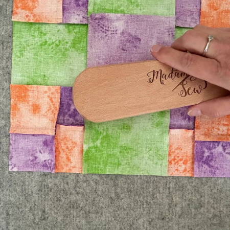 using a clapper to set the seams on a quilt block