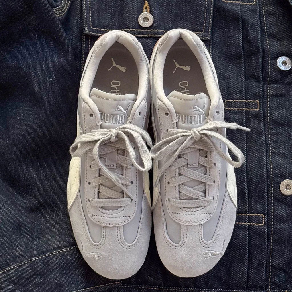 A pair of gray sneakers on a denim background.